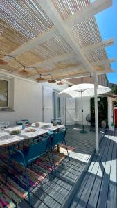 patio ze stołem i parasolem w obiekcie Villa Marquise w mieście Canet-en-Roussillon