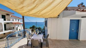 einen Tisch und Stühle auf einem Balkon mit Meerblick in der Unterkunft Cristina Studio Apartment in Póros