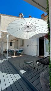 biały parasol na tarasie ze stołem i krzesłami w obiekcie Villa Marquise w mieście Canet-en-Roussillon