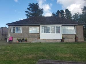 a house with a window and a lawn at Scotland Shooting Club Kirriemuir in Kirriemuir
