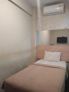 een slaapkamer met een bed en airconditioning aan de muur bij Royal Guesthouse Bandar Lampung in Bandar Lampung
