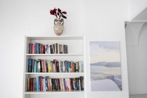 a book shelf filled with books with a vase on it at Hotel Star Santorini in Megalochori