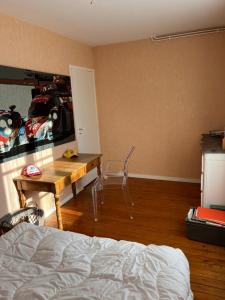 a bedroom with a bed and a desk and a table at Le Mans Kleber in Le Mans