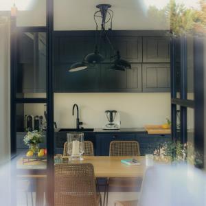 a kitchen with black cabinets and a wooden table at Wenning35 in Wenningstedt