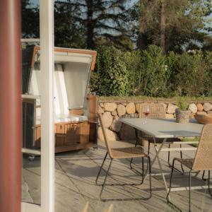 eine Terrasse mit einem Tisch, Stühlen und einem Grill in der Unterkunft Wenning35 in Wenningstedt-Braderup