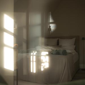 a bedroom with a white bed with a light shining on it at Wenning35 in Wenningstedt