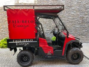 une voiturette de golf rouge garée à côté d'un bâtiment dans l'établissement Kuanza Nature Experience, Fajã do Belo, à Fajã da Caldeira de Santo Cristo