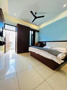 a bedroom with a bed and a ceiling fan at Hotel Anjum Regency in Bajaura