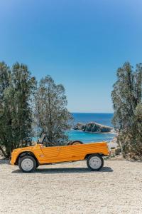 un coche amarillo estacionado en una playa cerca del océano en Cortijo La Loma en La Isleta del Moro