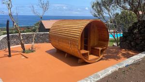 a small wooden boat sitting on top of a patio at Kuanza Nature Experience, Fajã do Belo in Fajã da Caldeira de Santo Cristo