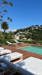 vista sulla piscina con sedie a sdraio di Villa La Pergola Capri a Capri