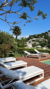 grupa leżaków i basen w obiekcie Villa La Pergola Capri w mieście Capri