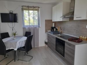 a small kitchen with a table and a table and chairs at IGGY in Malinska
