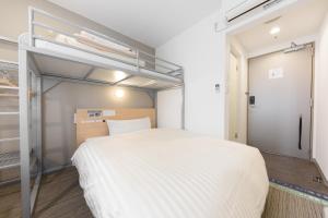 a bedroom with a large white bed in a room at Super Hotel Tokyo Otsuka in Tokyo