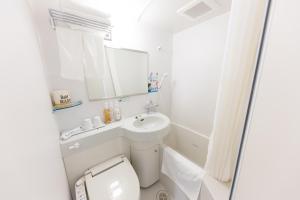 uma casa de banho com um WC, um lavatório e um espelho. em Super Hotel Tokyo Otsuka em Tóquio