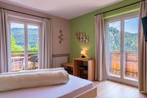 a bedroom with a bed and a balcony at Villa Gottfried B&B in Eggen