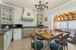 a kitchen with green cabinets and a wooden table and chairs at Casa Fife in Arrecife