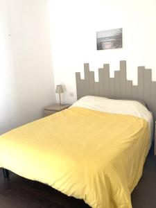 uma cama com uma colcha amarela num quarto em Maison Île d'Oléron - Proche plage em Grand-Village-Plage