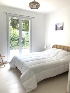 um quarto branco com uma cama grande e uma janela em Maison Île d'Oléron - Proche plage em Grand-Village-Plage