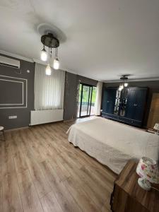 sypialnia z dużym łóżkiem i drewnianą podłogą w obiekcie alsaleh mersin villa w mieście Trabzon