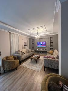 uma sala de estar com sofás e uma televisão de ecrã plano em alsaleh mersin villa em Trabzon