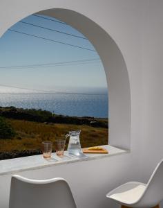 a room with a window with a view of the ocean at Thoè Oia Suites in Oia