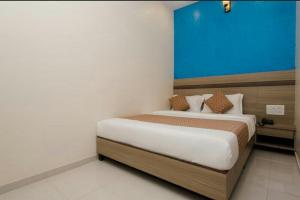 - une chambre avec un grand lit et un mur bleu dans l'établissement Hotel Golden Arch - NEAR DOMESTIC AIRPORT, à Mumbai