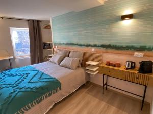 um quarto com uma cama e uma secretária com uma cama sidx sidx em Bubble rooms Chambres confortables en plein centre de Dieulefit em Dieulefit
