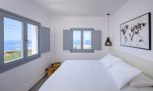 Кровать или кровати в номере Thoè Oia Suites