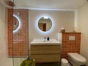 ein Badezimmer mit einem Waschbecken, einem WC und einem Spiegel in der Unterkunft Bubble rooms Chambres confortables en plein centre de Dieulefit in Dieulefit