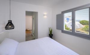 Кровать или кровати в номере Thoè Oia Suites