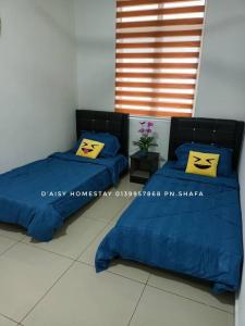 two beds with yellow pillows on them in a room at D'Aisy Homestay Sepang Klia Nilai in Sepang