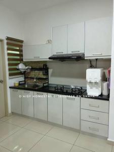 a kitchen with white cabinets and a counter top at D'Aisy Homestay Sepang Klia Nilai in Sepang