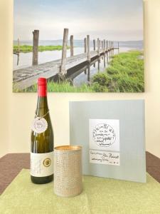 a bottle of wine and a picture of a pier at Alte Heimat in Schwegenheim