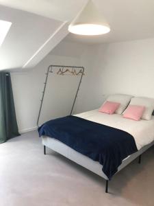 a bedroom with a bed with two pink pillows at Le 20 Les Terrasses. Maison de bord de Loire in Chalonnes-sur-Loire