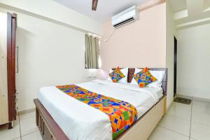 a bedroom with a large bed with colorful sheets at FabHotel Vishwa in Ahmedabad
