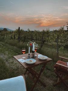 a picnic table in a field with wine glasses at POP Tiny House Balaton in Káptalantóti