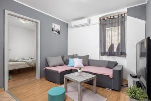 ein Wohnzimmer mit einem Sofa und einem Tisch in der Unterkunft Apartment KATI&ANA in Rijeka