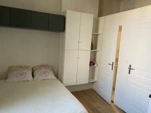 niewielka sypialnia z białymi szafkami i łóżkiem w obiekcie Chez Tony w mieście Périgueux