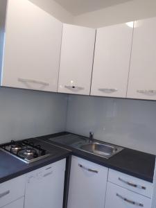 a kitchen with white cabinets and a sink at SEA VIEW sTUDIO MARIJETA in Tučepi