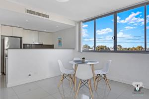 a kitchen and dining room with a table and chairs at KozyGuru / Parramatta / APT / NPA008 in Sydney