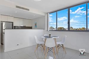 a kitchen and dining room with a table and chairs at KozyGuru | Parramatta | Clean Kozy APT | Free Wi-Fi in Sydney