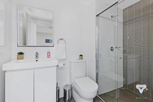 a white bathroom with a toilet and a shower at KozyGuru | Parramatta | Clean Kozy APT | Free Wi-Fi in Sydney