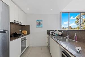 a kitchen with a sink and a window at KozyGuru | Parramatta | Clean Kozy APT | Free Wi-Fi in Sydney +6 photos