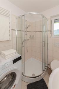 bagno con doccia e lavatrice di Hiša v zelenem a Bled