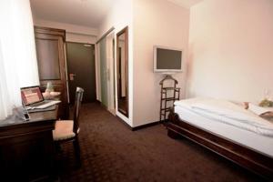 a bedroom with a bed and a desk and a computer at Althoff´s Landhotel in Ochtrup