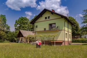 una famiglia in piedi in un campo di fronte a una casa di Hiša v zelenem a Bled