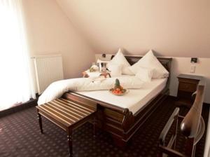 a bedroom with a bed and a table with a bowl on it at Althoff´s Landhotel in Ochtrup