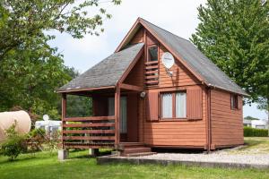 a small wooden cabin with a gambrel roof at Camping les falaises de Toussaint in Toussaint