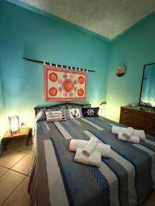 una camera da letto con un grande letto con asciugamani di Delfino House a Terrasini